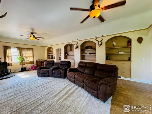 a living room with furniture a rug and white walls