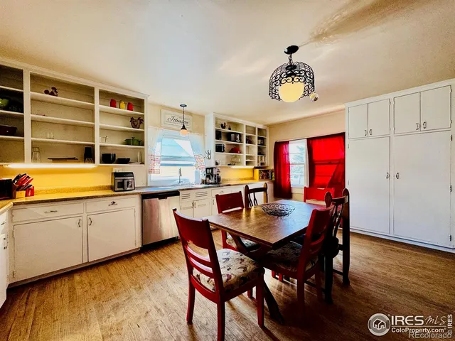 a dining hall with stainless steel appliances kitchen island granite countertop furniture and a window