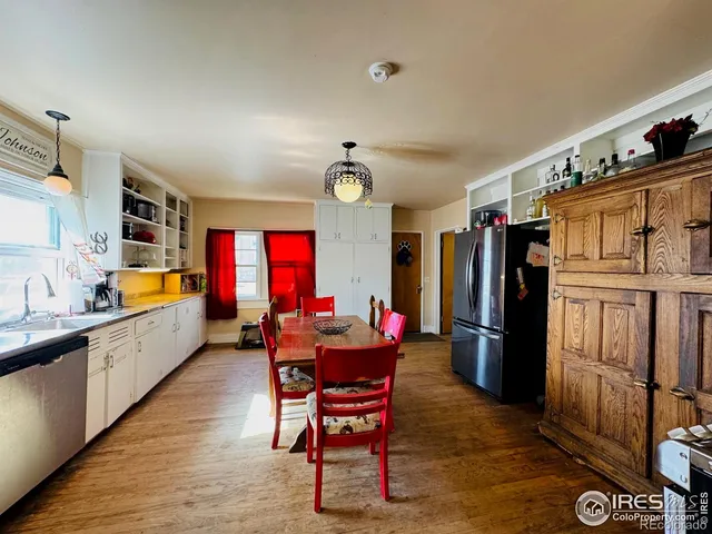 a kitchen with stainless steel appliances kitchen island granite countertop a table chairs in it and wooden floors