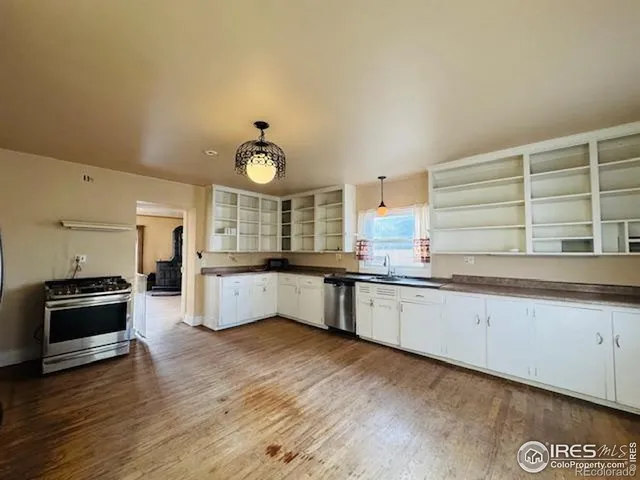 a large kitchen with granite countertop a stove two sinks a refrigerator and a dishwasher