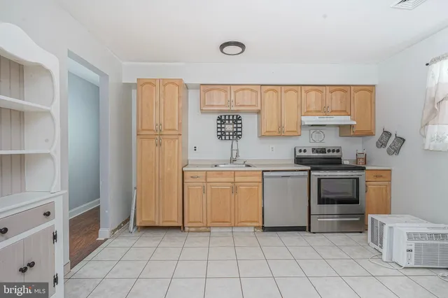 a kitchen with a stove sink and cabinets