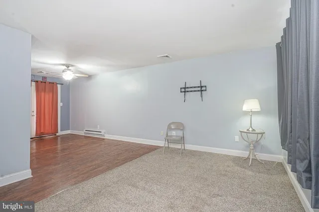 a view of a room with wooden floor and fan
