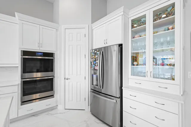 a kitchen with stainless steel appliances a sink a stove and white cabinets