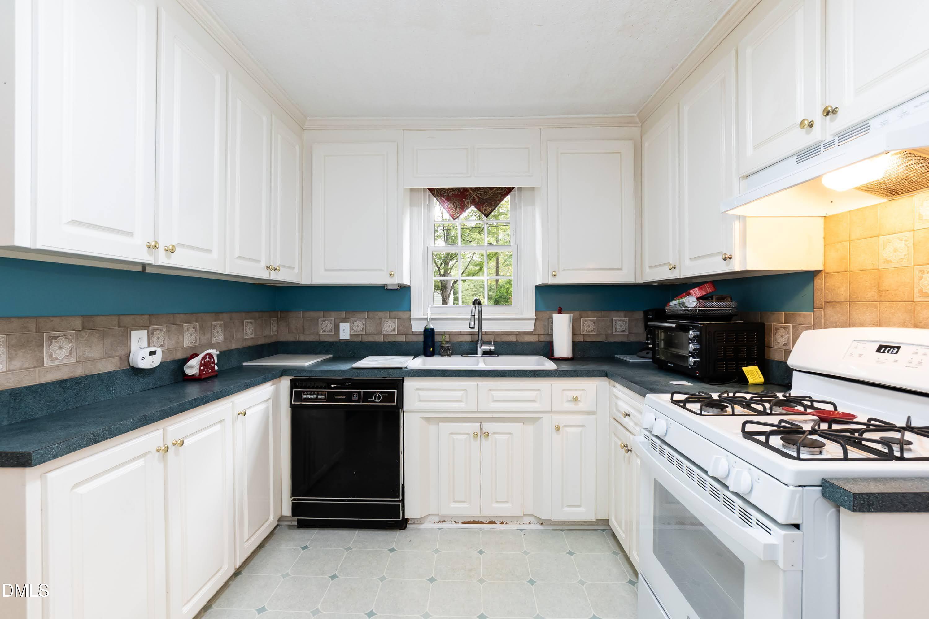 700 St Marys Street Garner, NC 27529 - Photo 17 of 51 a kitchen with white cabinets and appliances