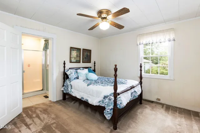 a bed sitting in a bedroom next to a window