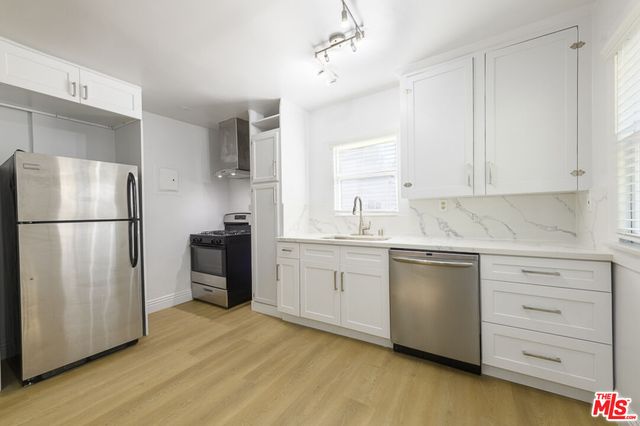 a kitchen with a refrigerator sink and cabinets