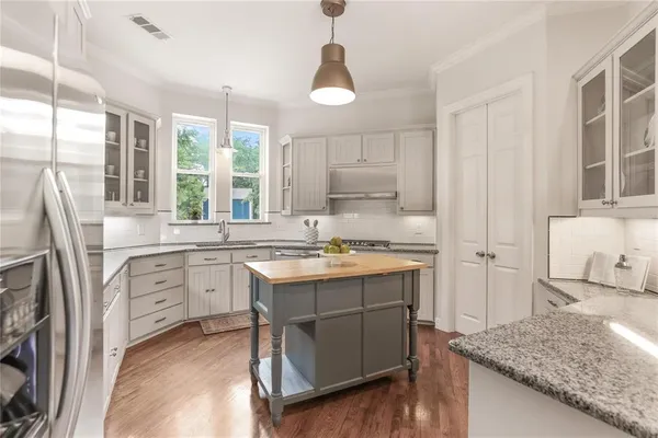 a kitchen with white cabinets and sink