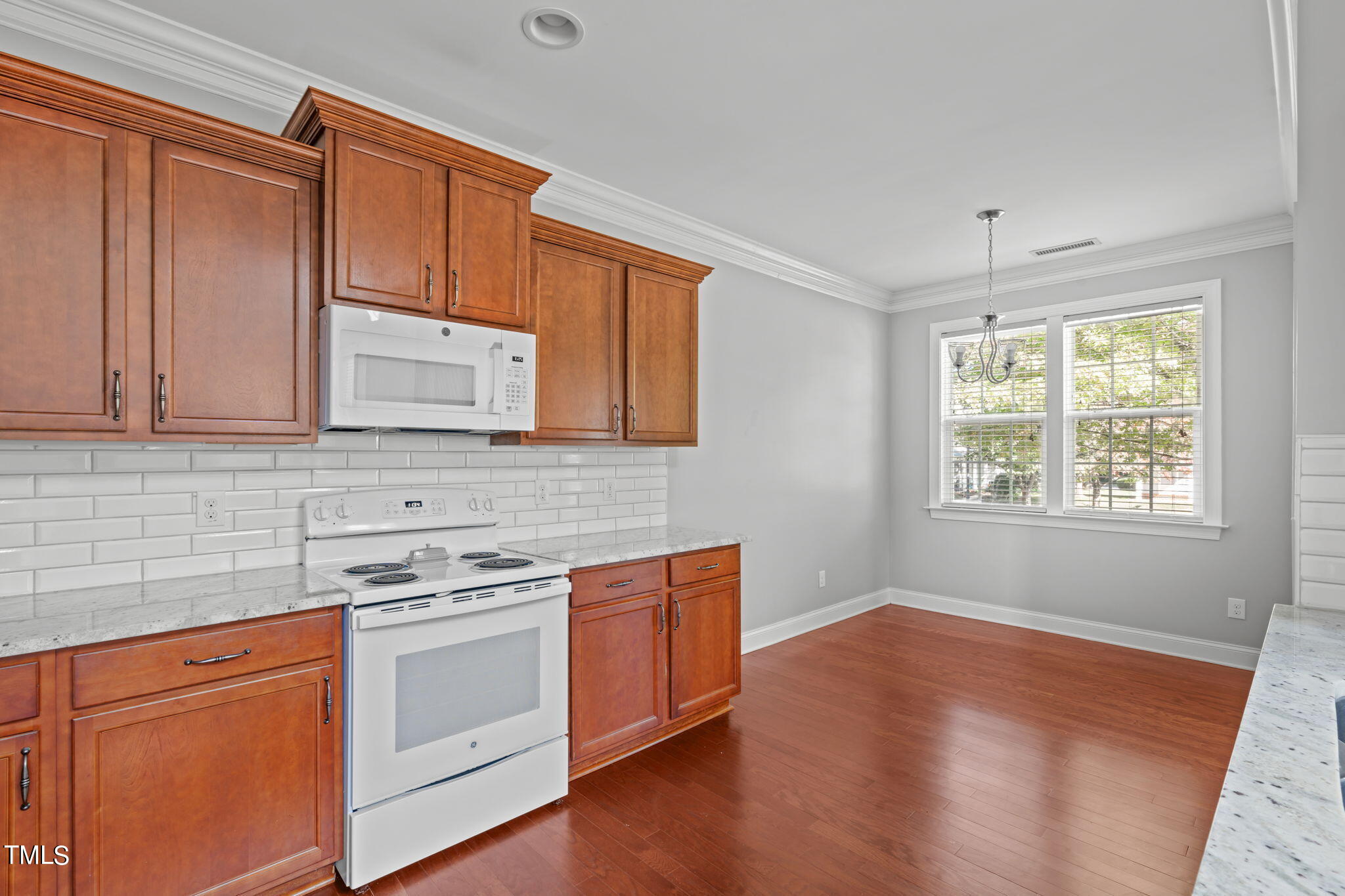 601 Democracy Street Raleigh, NC 27603 - Photo 10 of 24 a kitchen with stainless steel appliances granite countertop a stove a sink and a microwave