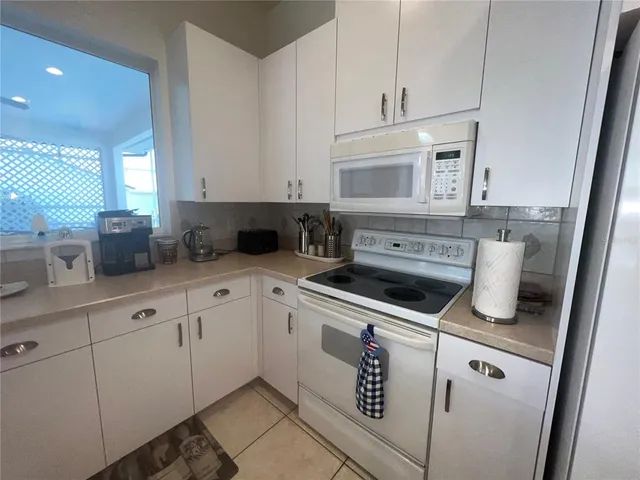 a kitchen with white cabinets and white appliances