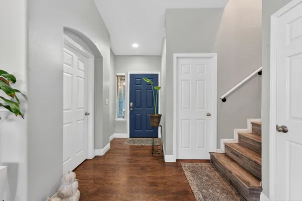 a view of a hallway with wooden floor and entryway