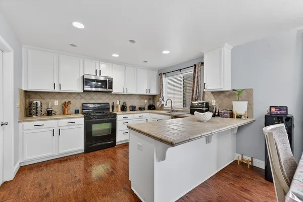 a kitchen with appliances a sink and cabinets