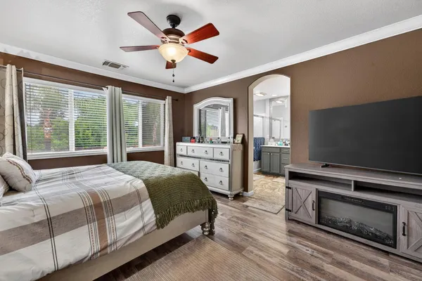 a bedroom with a bed and a flat screen tv with kitchen view