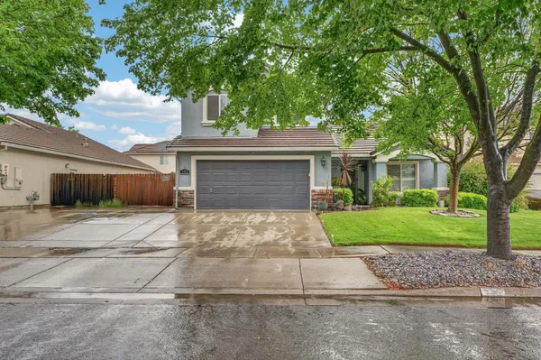 a front view of a house with a yard and a garage