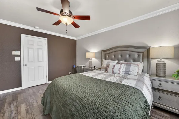 a bedroom with a large bed and a ceiling fan
