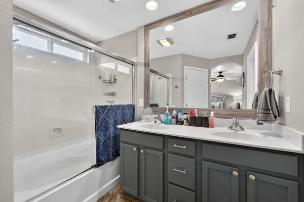 a bathroom with a bathtub shower sink double and mirror