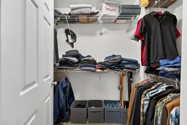 a view of walk in closet with clothes and shoes