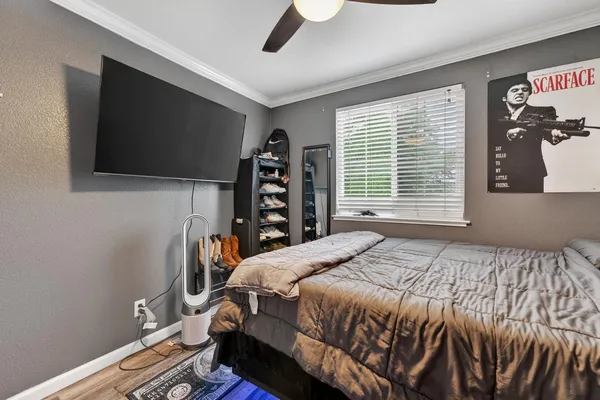 a bedroom with a bed a flat screen tv and a large window