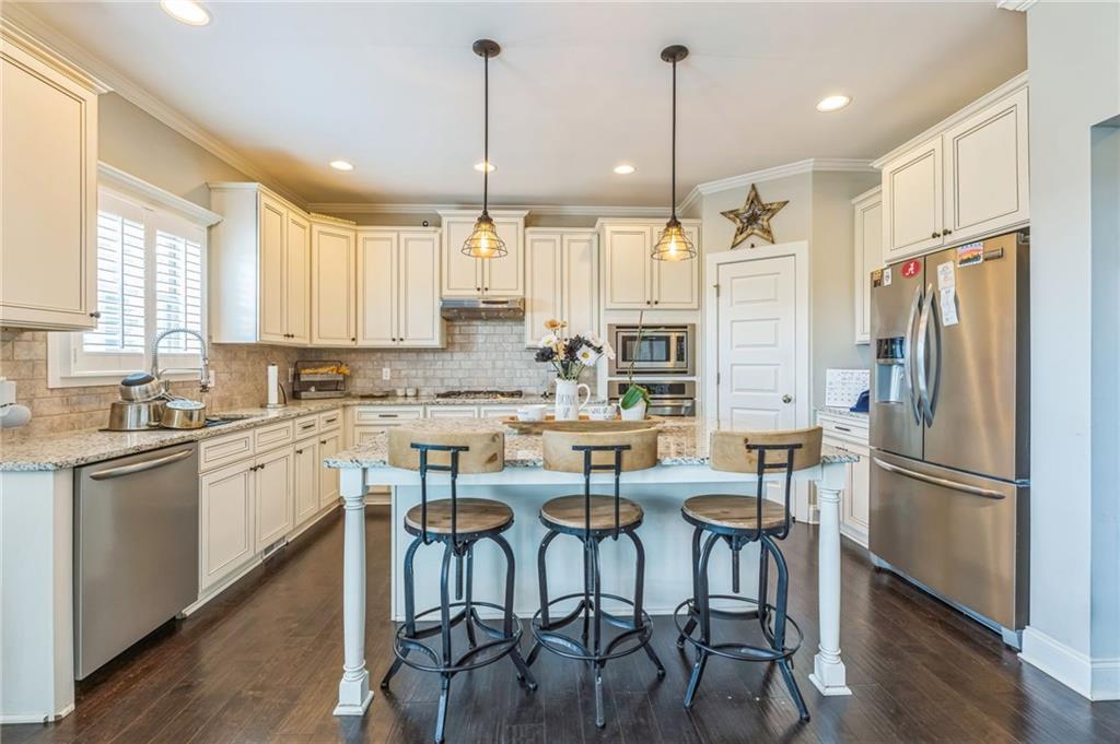 1621 Highland Creek Drive Monroe, GA 30656 - Photo 12 of 54 a kitchen with stainless steel appliances granite countertop a refrigerator a sink a stove a dining table and chairs