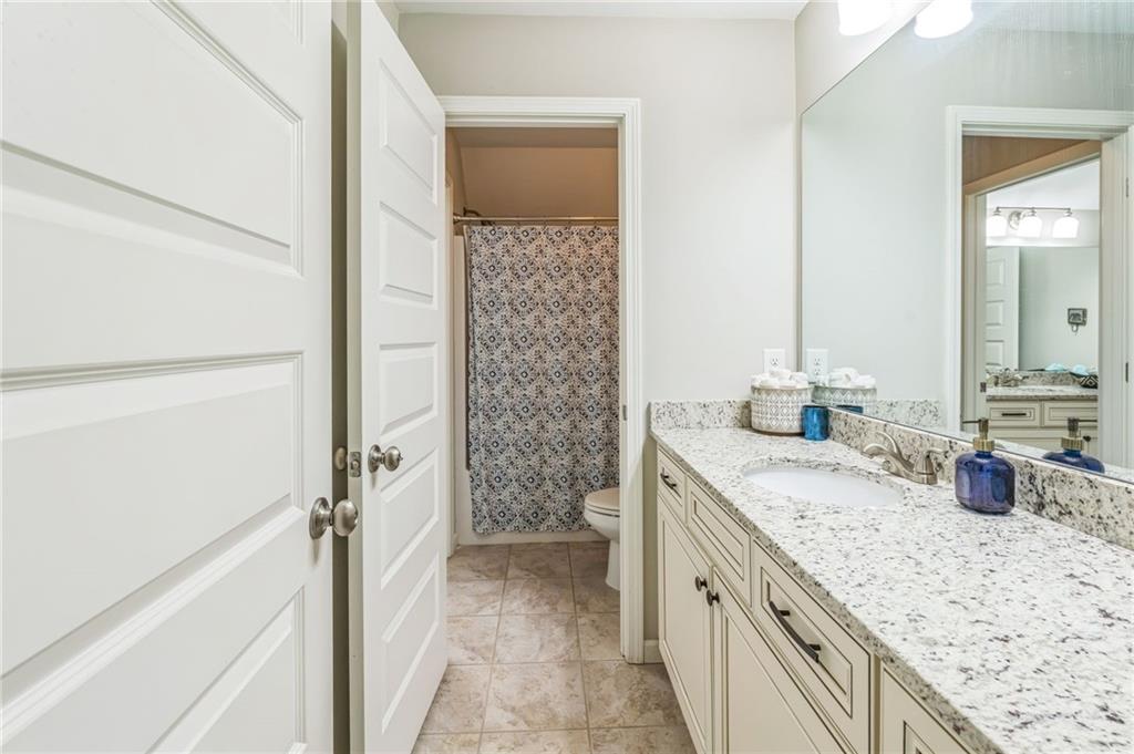 1621 Highland Creek Drive Monroe, GA 30656 - Photo 31 of 54 a bathroom with a granite countertop sink a mirror and shower