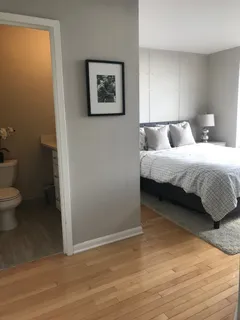 a spacious bedroom with a bed and a wall painting