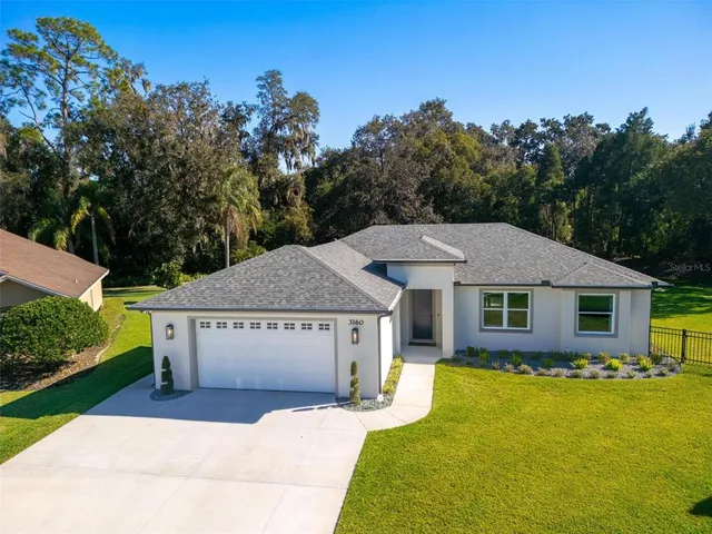 a view of a house with a yard and tree s