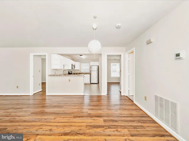 a view of kitchen and hall with wooden floor