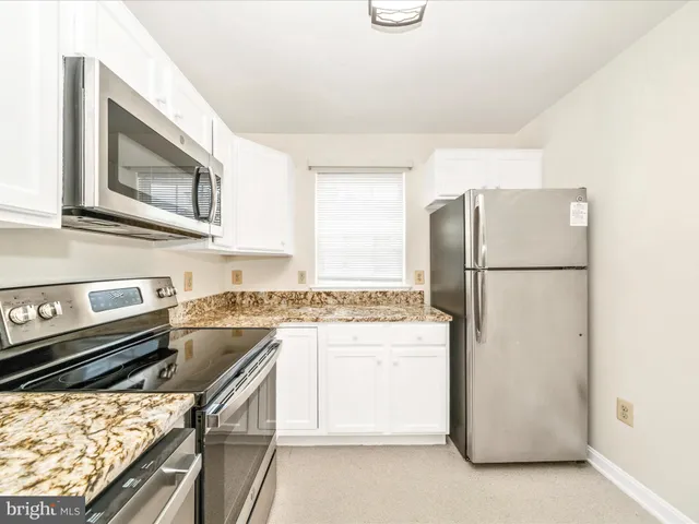a kitchen with a refrigerator and a stove