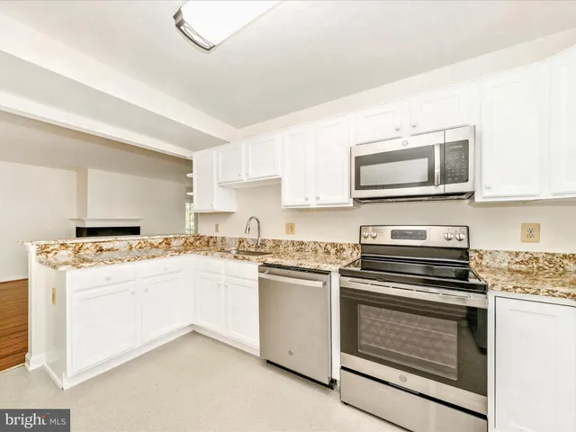 a kitchen with stainless steel appliances a stove microwave and cabinets