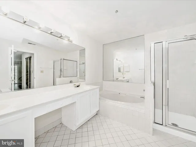 a spacious bathroom with a tub sink and mirror