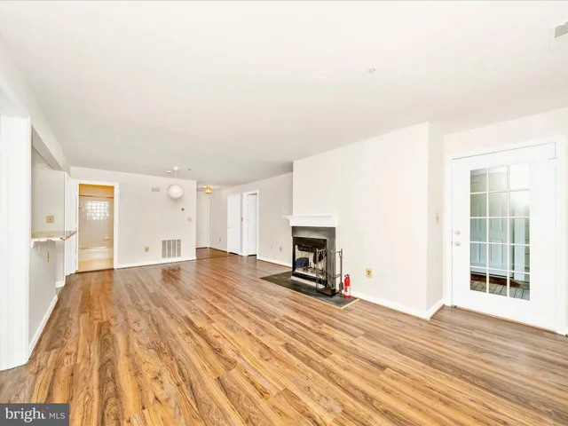 a view of empty room with wooden floor and fireplace