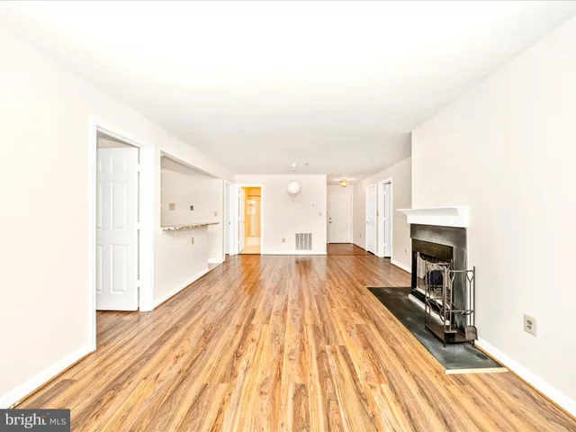 a view of a hallway with wooden floor and a fireplace