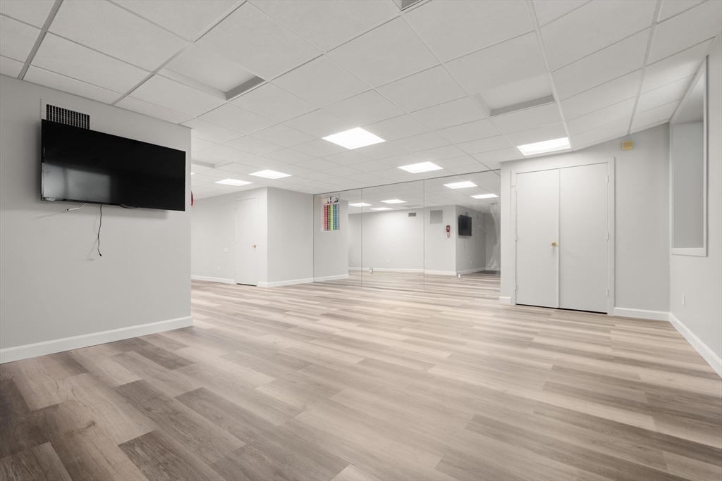 214 Allandale Road, Unit B Boston, MA 02467 - Photo 31 of 35 a view of an empty room with wooden floor and a window