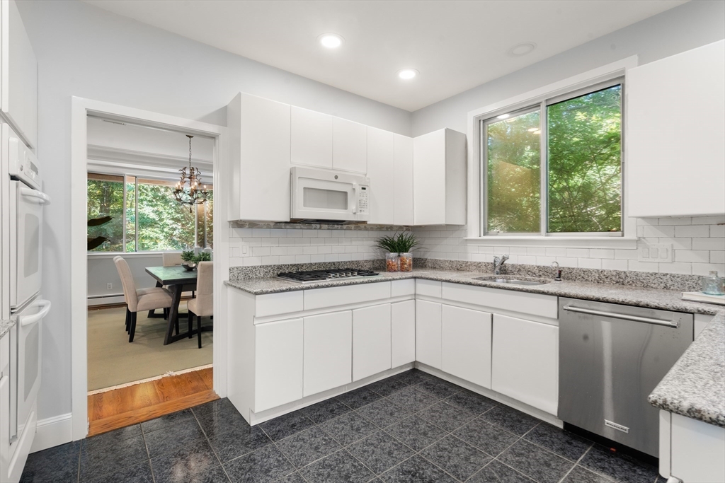 214 Allandale Road, Unit B Boston, MA 02467 - Photo 10 of 35 a kitchen with stainless steel appliances granite countertop a stove a sink and a microwave