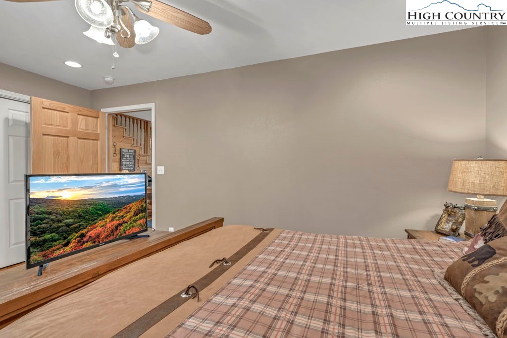883 Wagon Ridge Road Ferguson, NC 28624 - Photo 18 of 50 a bedroom with a bed and a flat tv screen on dresser
