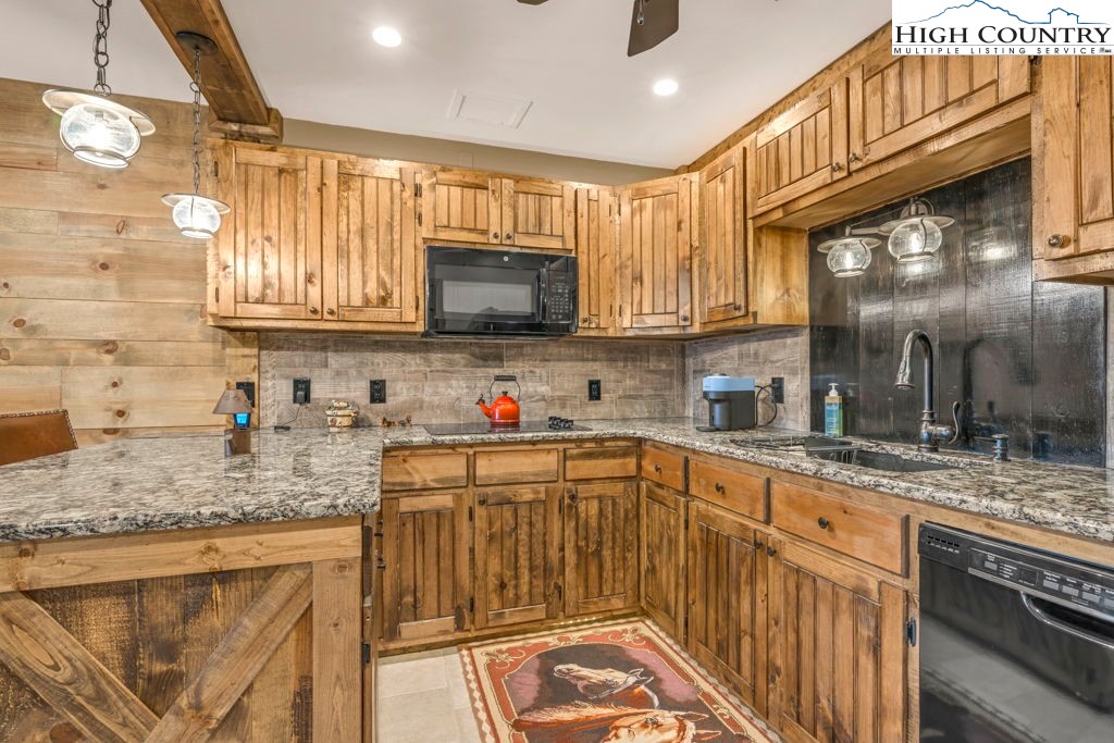 883 Wagon Ridge Road Ferguson, NC 28624 - Photo 34 of 50 a kitchen with stainless steel appliances granite countertop a sink stove microwave and cabinets