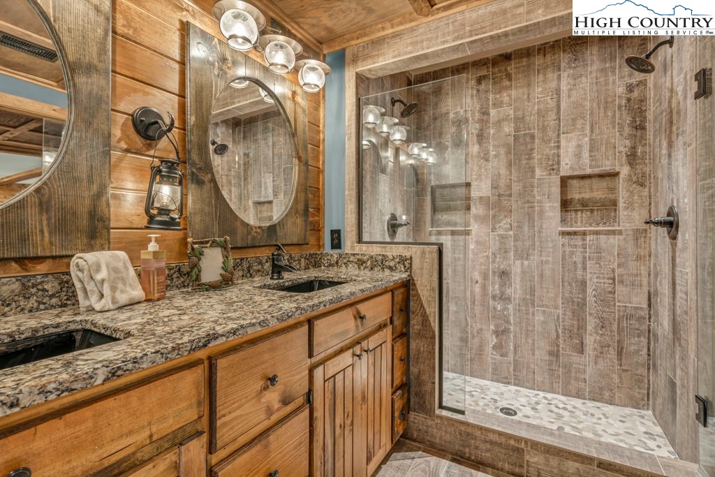 883 Wagon Ridge Road Ferguson, NC 28624 - Photo 38 of 50 a bathroom with a granite countertop sink and a mirror