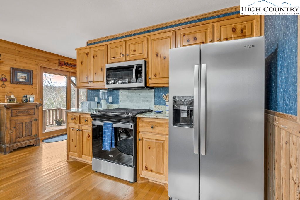 883 Wagon Ridge Road Ferguson, NC 28624 - Photo 9 of 50 a kitchen with stainless steel appliances granite countertop a refrigerator and a stove top oven