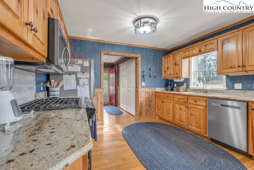 883 Wagon Ridge Road Ferguson, NC 28624 - Photo 10 of 50 a large kitchen with stainless steel appliances granite countertop a stove a sink and a granite counter tops with white cabinets