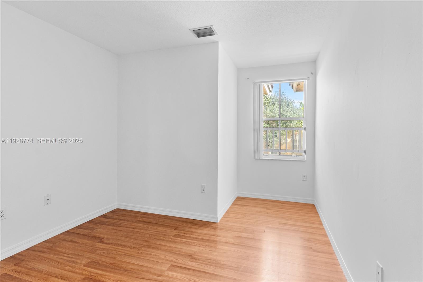 3168 Southwest 129th Way, Unit 151 Miramar, FL 33027 - Photo 20 of 21 a view of an empty room with wooden floor and a window