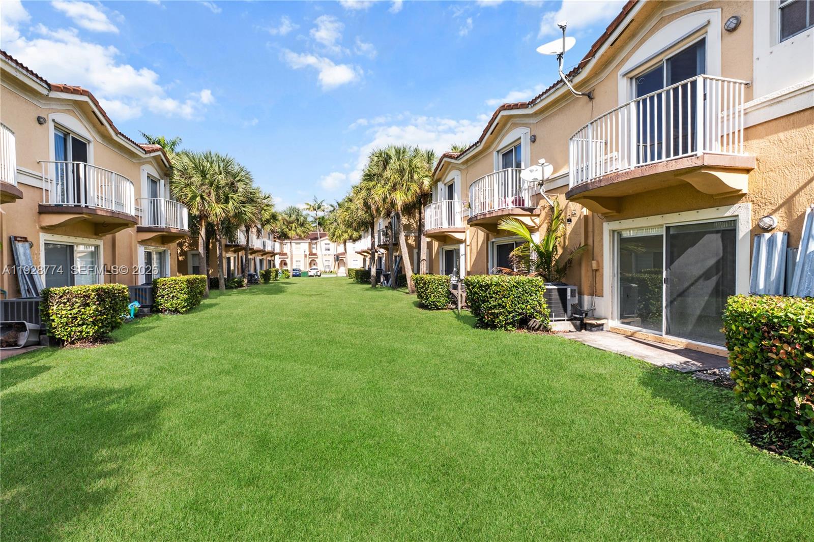 3168 Southwest 129th Way, Unit 151 Miramar, FL 33027 - Photo 2 of 21 a view of a white house with a big yard and potted plants