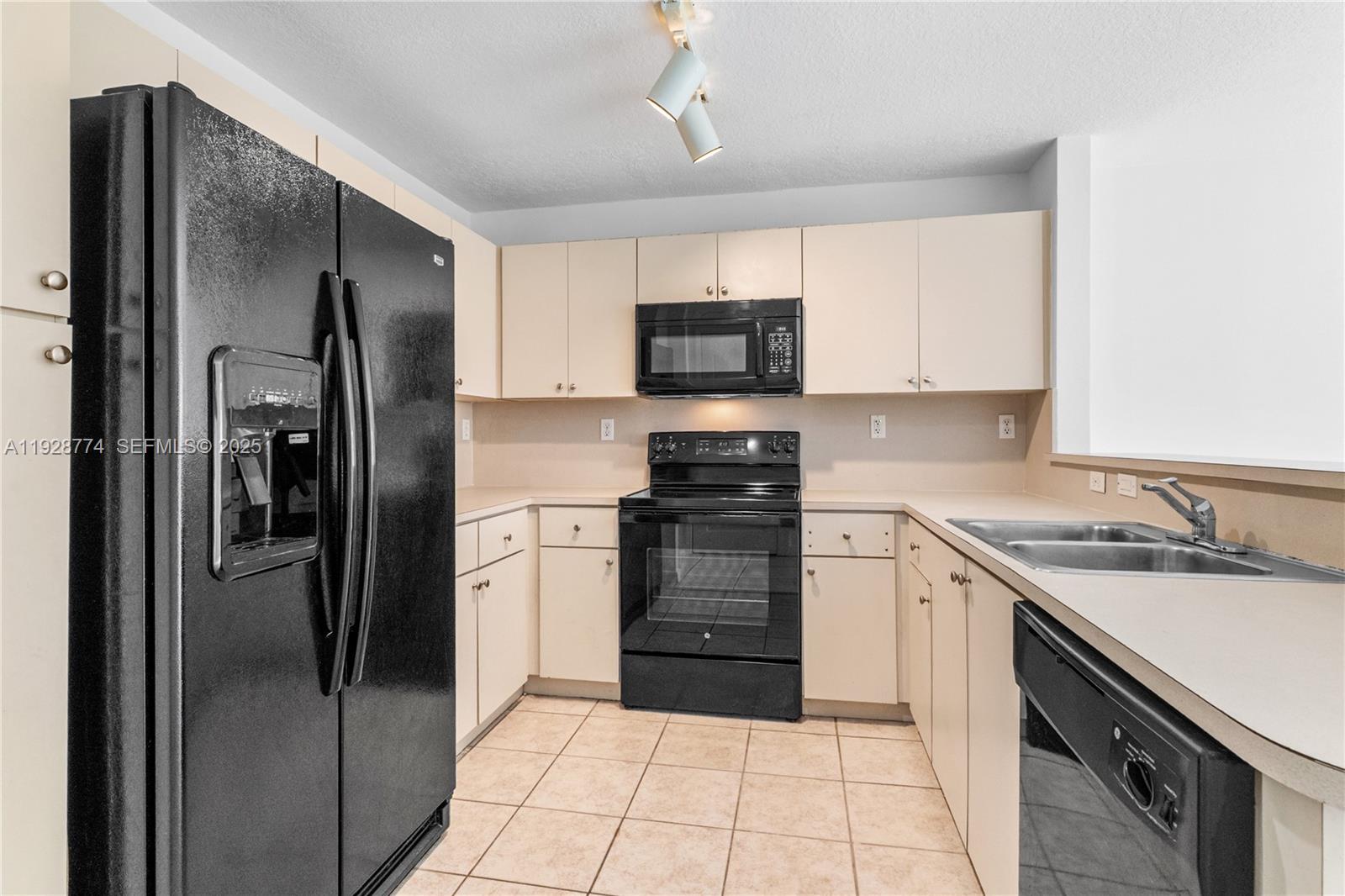 3168 Southwest 129th Way, Unit 151 Miramar, FL 33027 - Photo 5 of 21 a kitchen with a refrigerator sink and cabinets