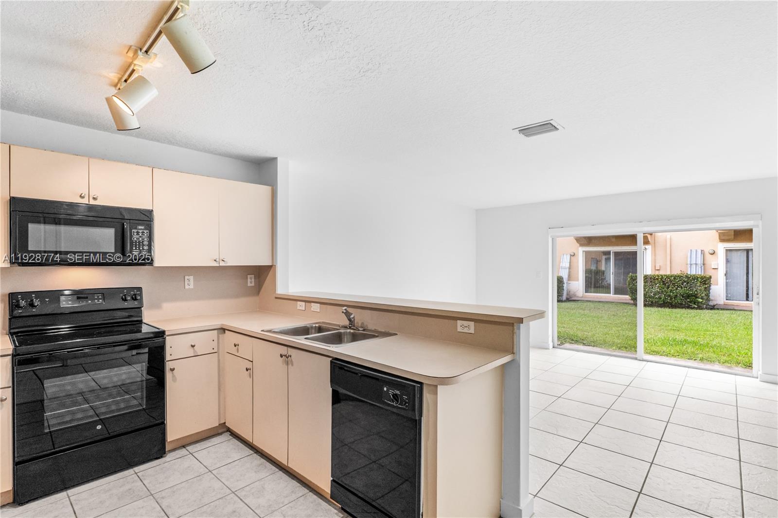 3168 Southwest 129th Way, Unit 151 Miramar, FL 33027 - Photo 8 of 21 a kitchen with a stove a sink and a refrigerator