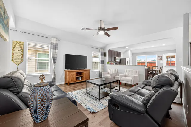 a living room with furniture kitchen view and a flat screen tv