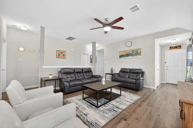 a living room with furniture and wooden floor