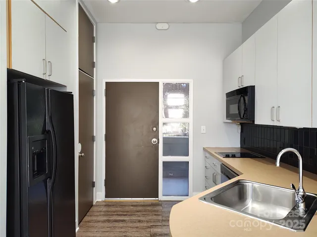 a kitchen with a refrigerator sink and cabinets
