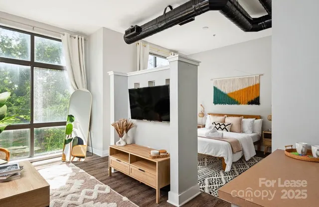a living room with furniture a flat screen tv and a floor to ceiling window