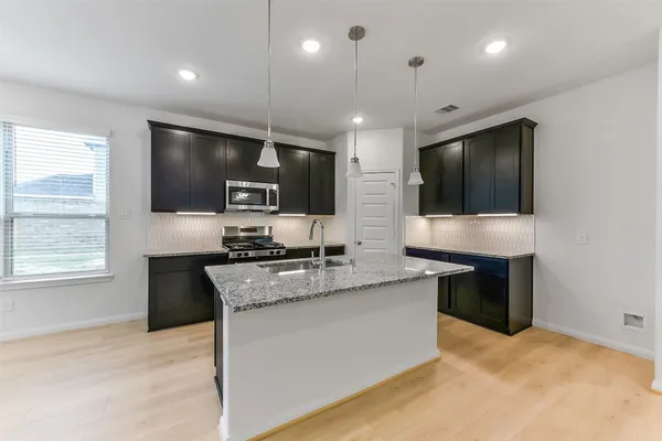 a kitchen with stainless steel appliances granite countertop a sink stove and refrigerator