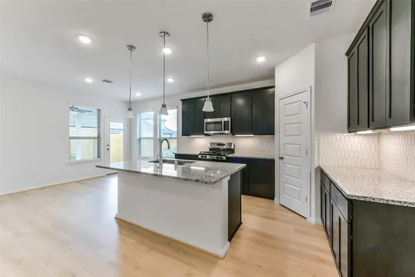 a kitchen with stainless steel appliances granite countertop a sink stove and refrigerator
