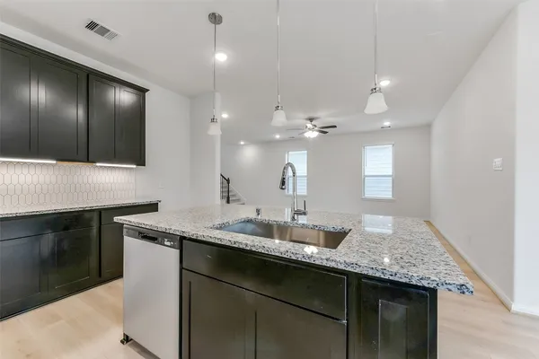 a kitchen with stainless steel appliances granite countertop a stove a sink and a microwave