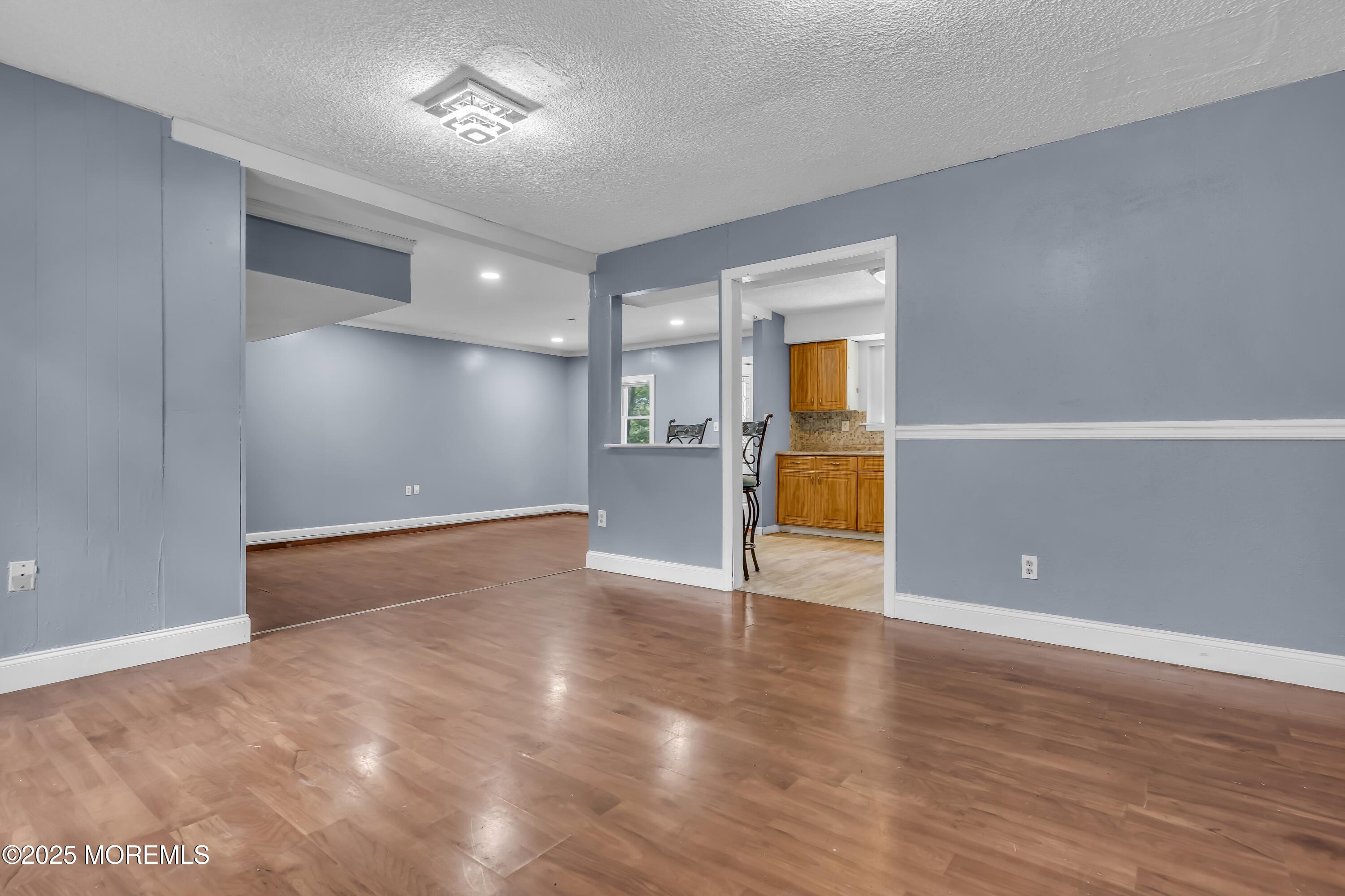 32 1st Street Barnegat, NJ 08005 - Photo 5 of 16 a view of an empty room with wooden floor and a window
